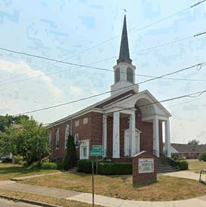 A church with a steeple on the side of the road

AI-generated content may be incorrect.